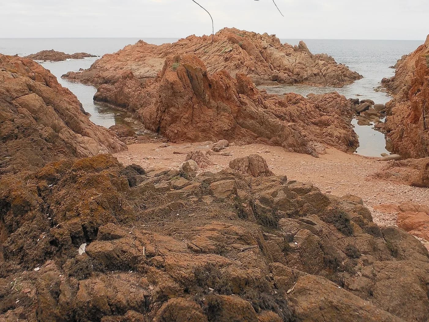 Rochers de porphyre rouge et petite crique de sable à Isola Rossa, Trinità d'Agultu