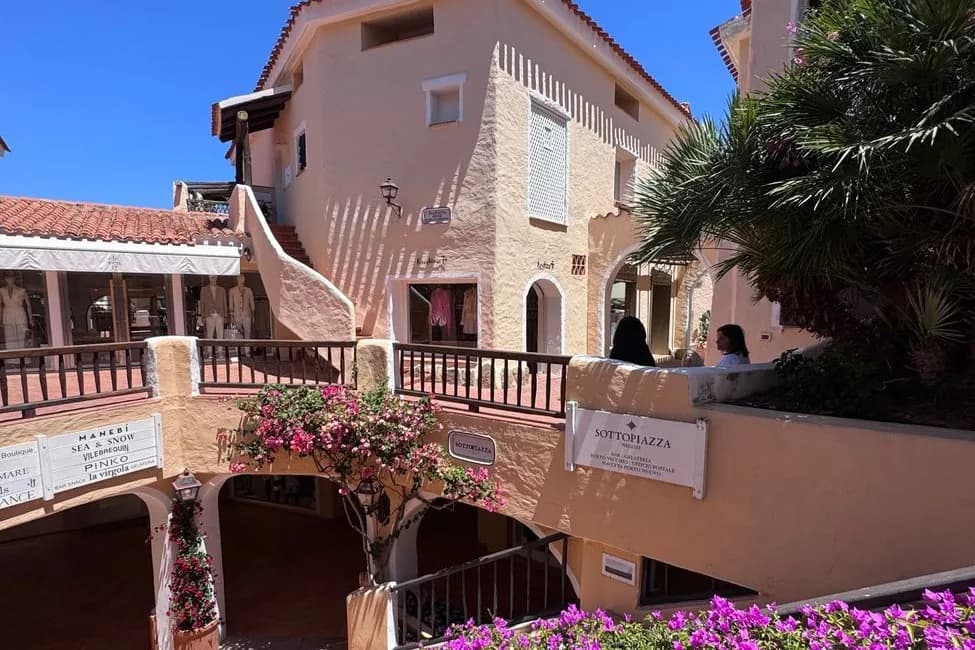 Ruelles et arcades ocre-rose de la Piazzetta de Porto Cervo, avec bougainvilliers