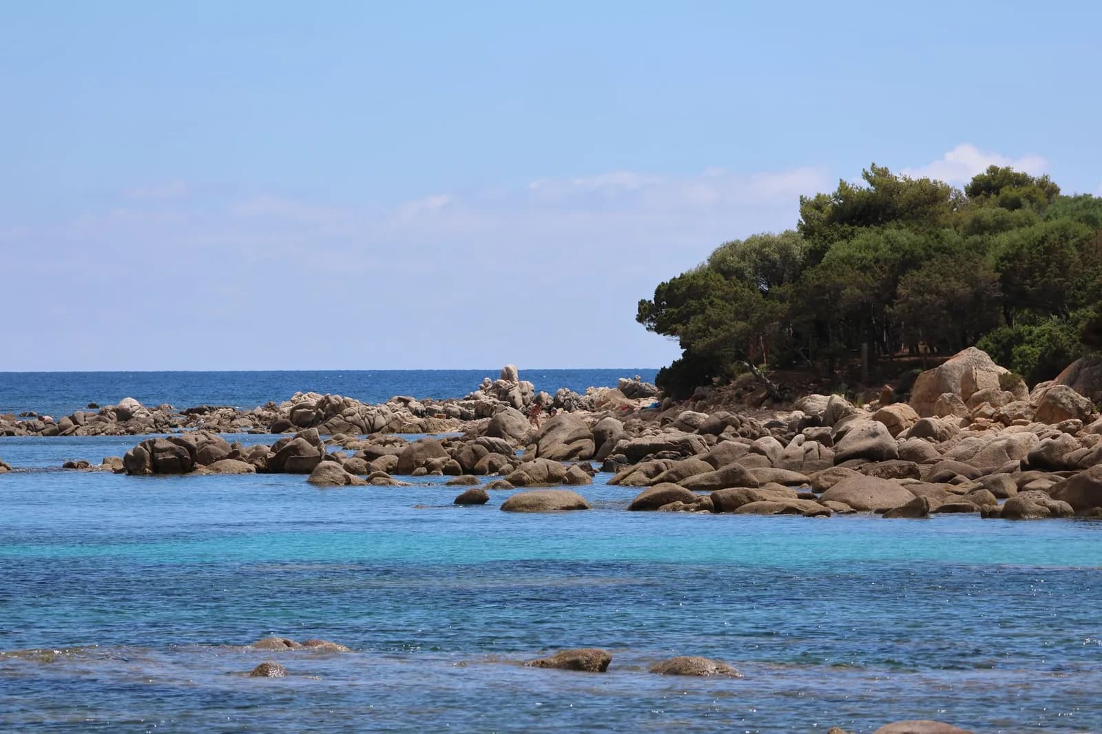 Rochers de granit et arbres dans une eau turquoise sur la côte nord-est de la Sardaigne